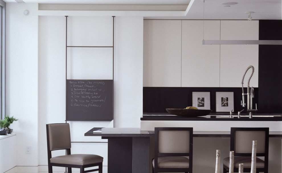 Immagine di una cucina design con lavello sottopiano, ante lisce e paraspruzzi nero