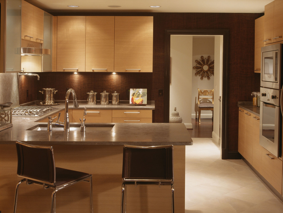 ボルチモアにあるコンテンポラリースタイルのおしゃれなキッチン (シルバーの調理設備、シングルシンク、淡色木目調キャビネット、ライムストーンカウンター) の写真
