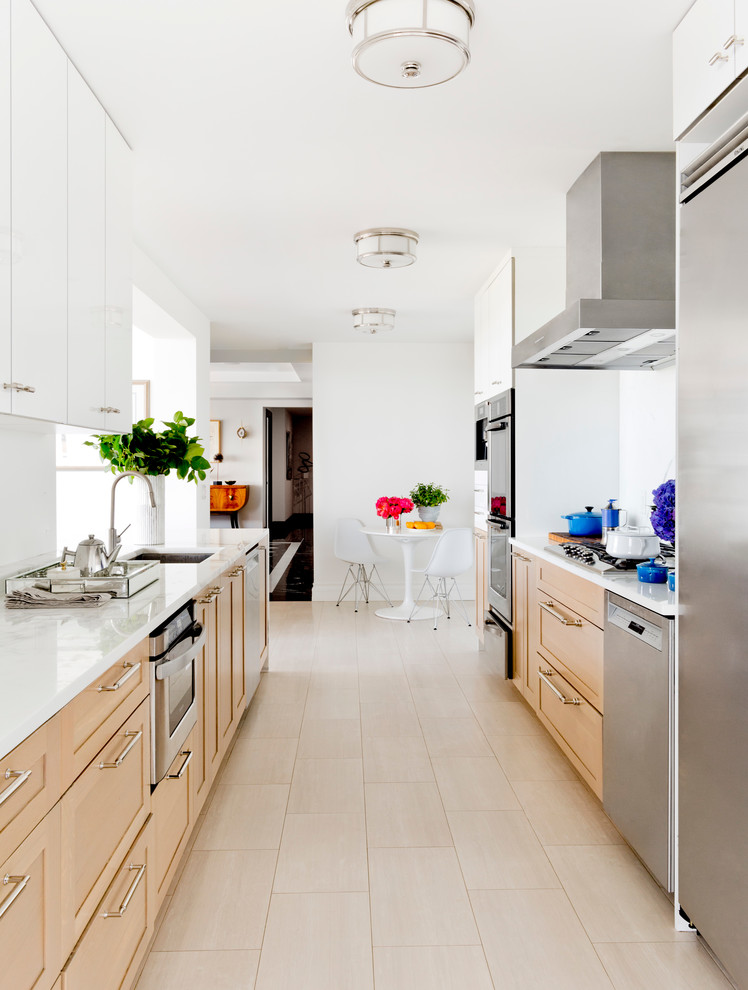 Inspiration for a large modern galley kitchen in New York with a submerged sink, shaker cabinets, light wood cabinets, marble worktops, white splashback, stone slab splashback, stainless steel appliances, porcelain flooring and a breakfast bar.