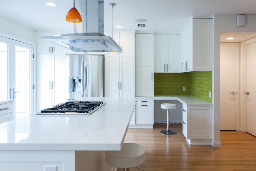 Example of a small trendy u-shaped medium tone wood floor eat-in kitchen design in Orange County with a double-bowl sink, shaker cabinets, white cabinets, quartzite countertops, green backsplash, porcelain backsplash, stainless steel appliances and an island