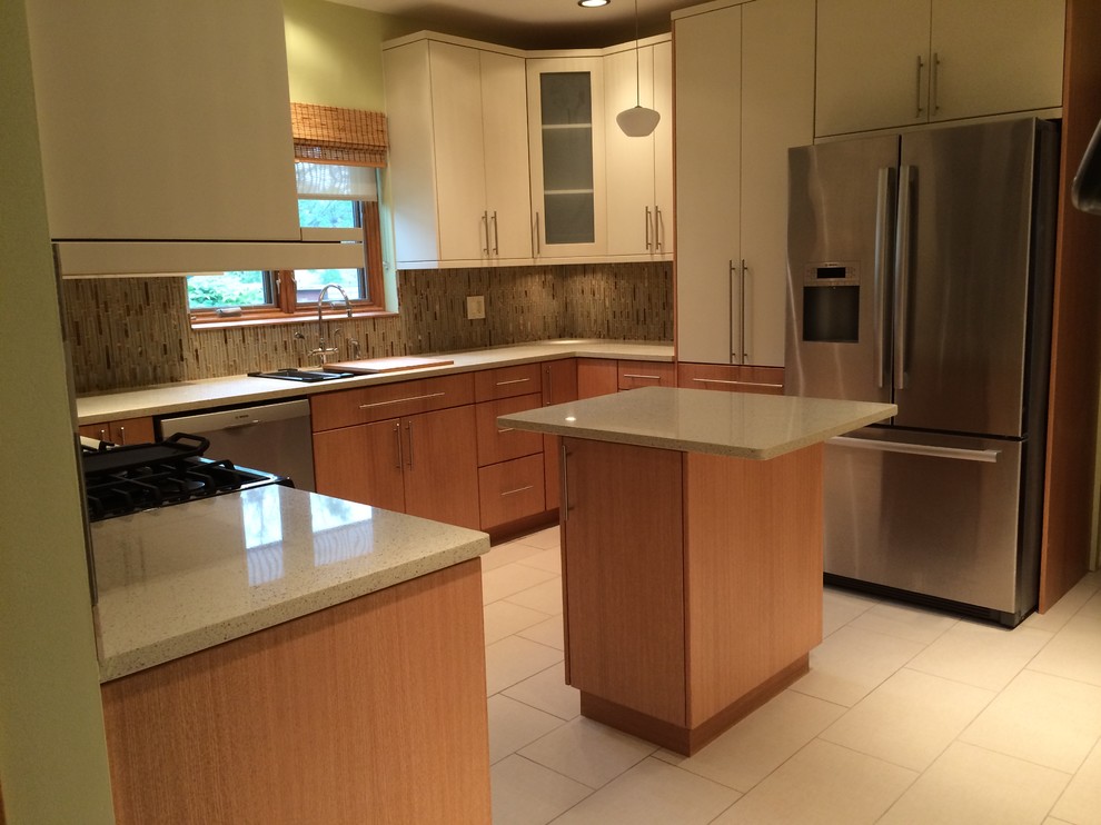 Modern inredning av ett mellanstort u-kök, med en undermonterad diskho, släta luckor, skåp i mellenmörkt trä, bänkskiva i kvarts, grönt stänkskydd, stänkskydd i mosaik, vita vitvaror, klinkergolv i porslin och en köksö