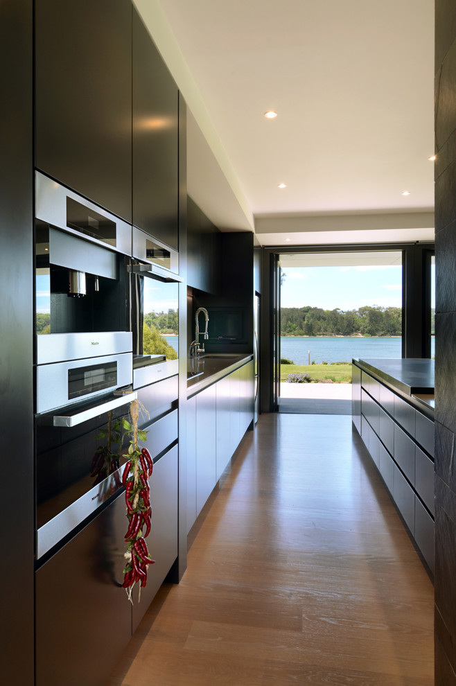 Foto di una grande cucina design con ante lisce e ante nere