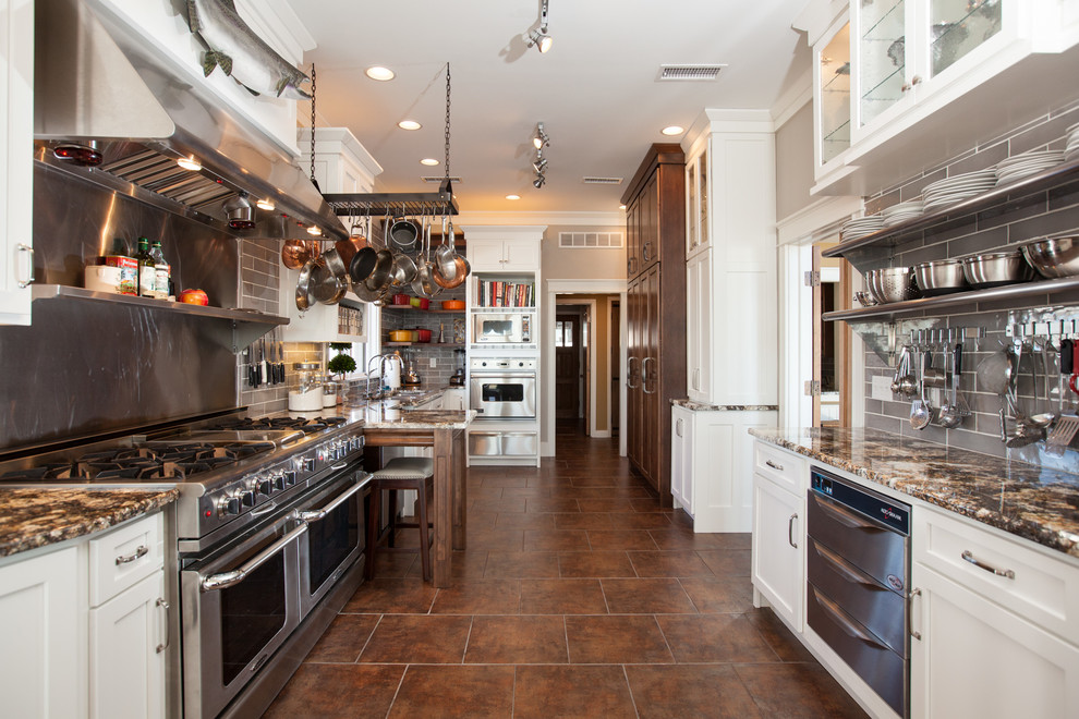Immagine di una cucina parallela tradizionale chiusa con ante di vetro, ante bianche, paraspruzzi grigio, paraspruzzi con piastrelle diamantate, elettrodomestici in acciaio inossidabile e pavimento marrone