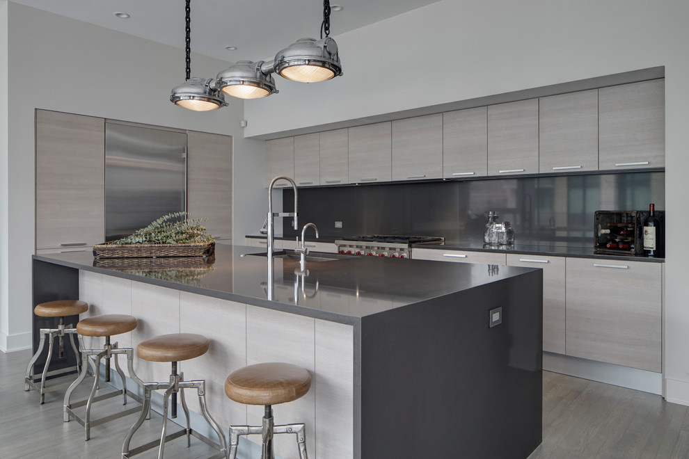 Moderne Küche in L-Form mit flächenbündigen Schrankfronten, grauen Schränken, Küchenrückwand in Grau, Küchengeräten aus Edelstahl und Kücheninsel in Chicago