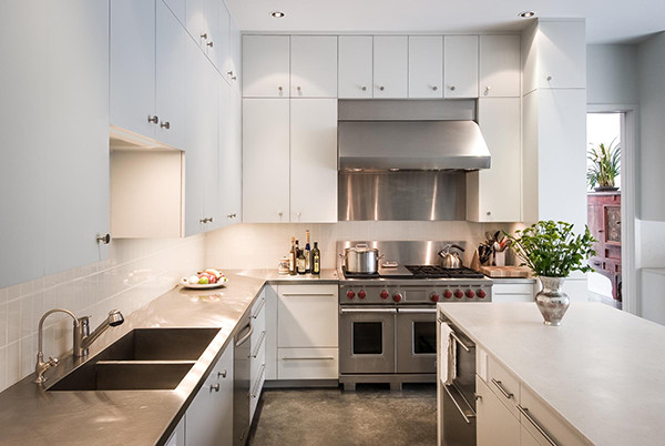 Example of a large transitional u-shaped concrete floor eat-in kitchen design in Houston with a double-bowl sink, flat-panel cabinets, white cabinets, solid surface countertops, white backsplash, ceramic backsplash, stainless steel appliances and an island