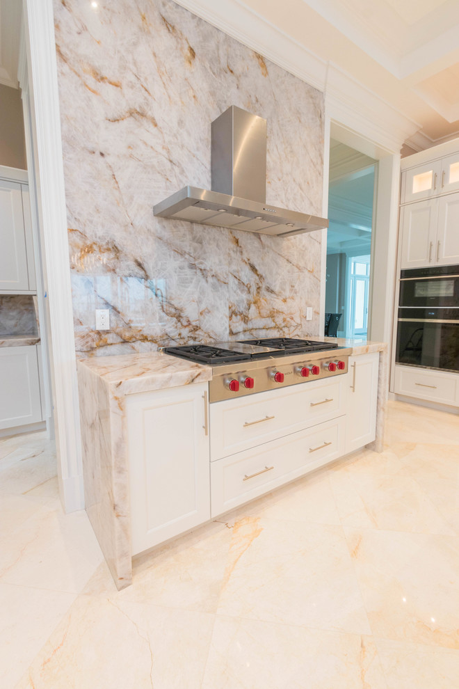Expansive classic u-shaped open plan kitchen in Other with a submerged sink, flat-panel cabinets, white cabinets, quartz worktops, white splashback, stone slab splashback, marble flooring, multiple islands and white floors.