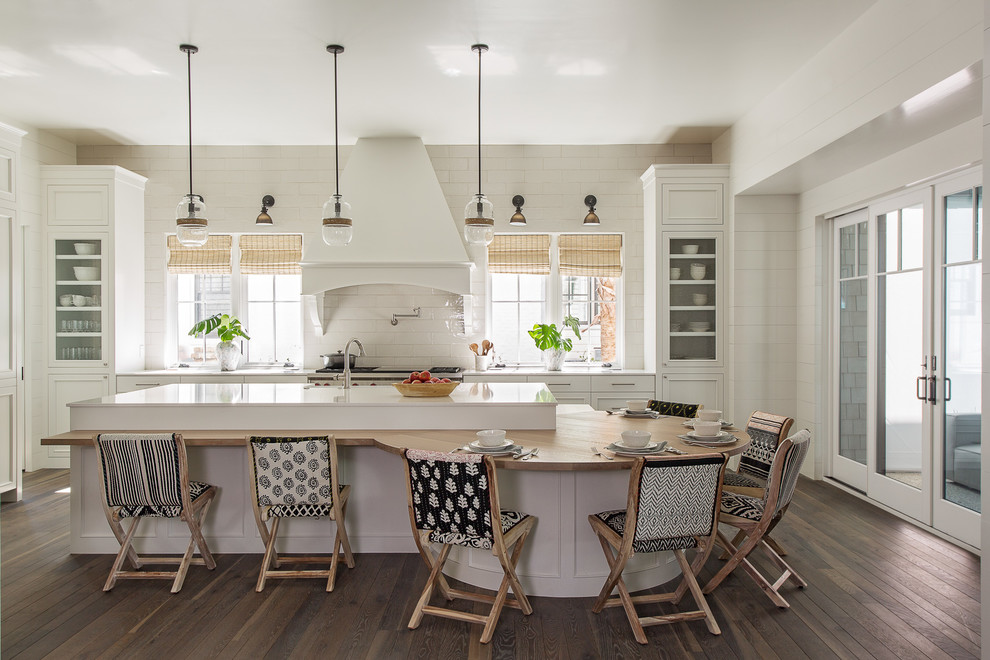 Example of a beach style l-shaped dark wood floor and brown floor eat-in kitchen design in Charleston with recessed-panel cabinets, white cabinets, white backsplash, stainless steel appliances, an island and white countertops