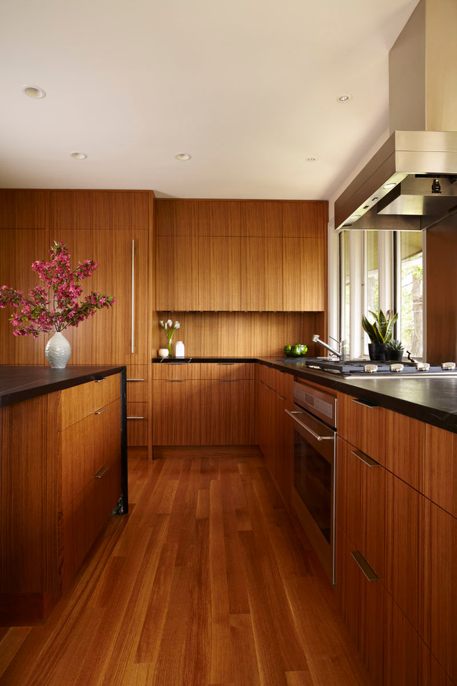 Inspiration for a modern kitchen remodel in Minneapolis with flat-panel cabinets, medium tone wood cabinets and paneled appliances