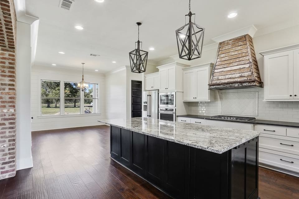 Enclosed kitchen - mid-sized traditional l-shaped dark wood floor and brown floor enclosed kitchen idea in New Orleans with shaker cabinets, white cabinets, granite countertops, white backsplash, subway tile backsplash, stainless steel appliances, an island and gray countertops