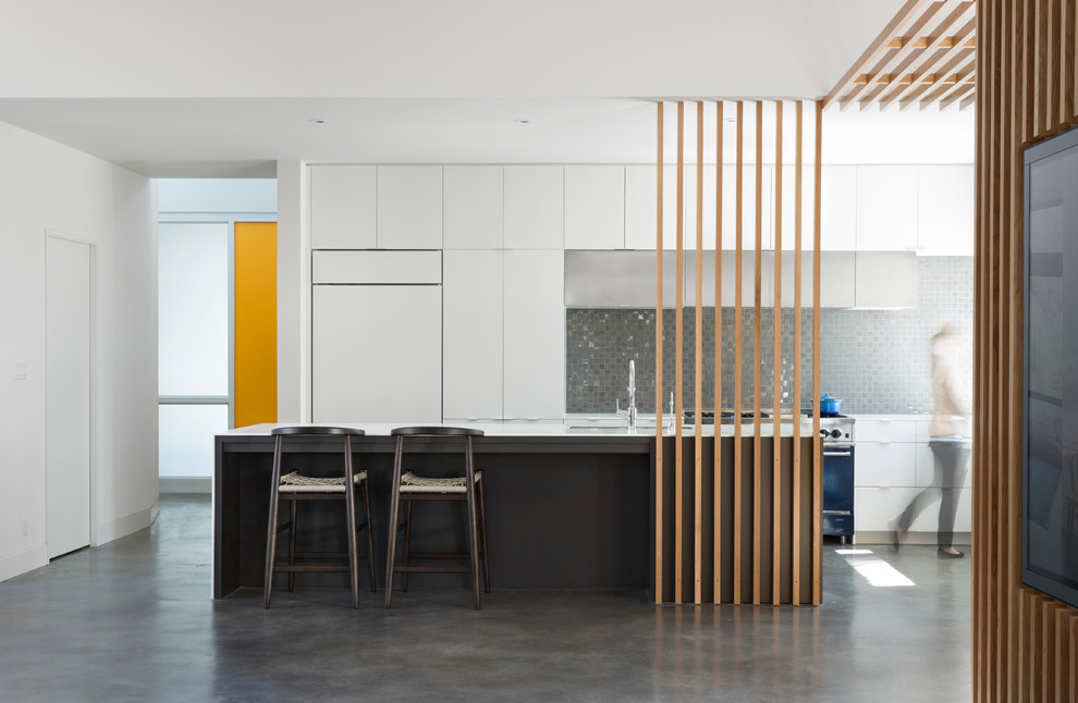 Idee per una cucina moderna con ante lisce, ante bianche, paraspruzzi a effetto metallico e pavimento in cemento