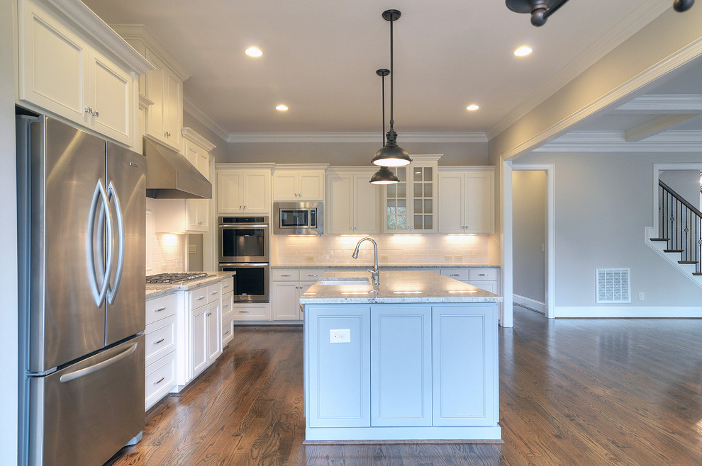 Inspiration for a large timeless l-shaped dark wood floor open concept kitchen remodel in Charlotte with a farmhouse sink, flat-panel cabinets, white cabinets, granite countertops, white backsplash, ceramic backsplash, stainless steel appliances and an island