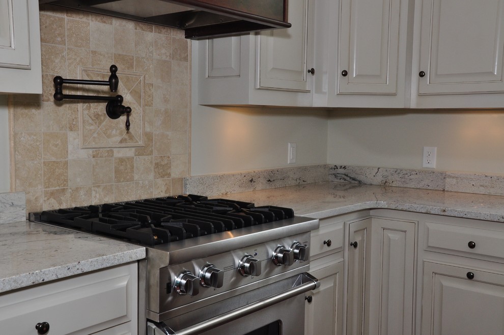 Inredning av ett modernt stort kök, med luckor med upphöjd panel, vita skåp, granitbänkskiva, beige stänkskydd, rostfria vitvaror, mörkt trägolv och en köksö