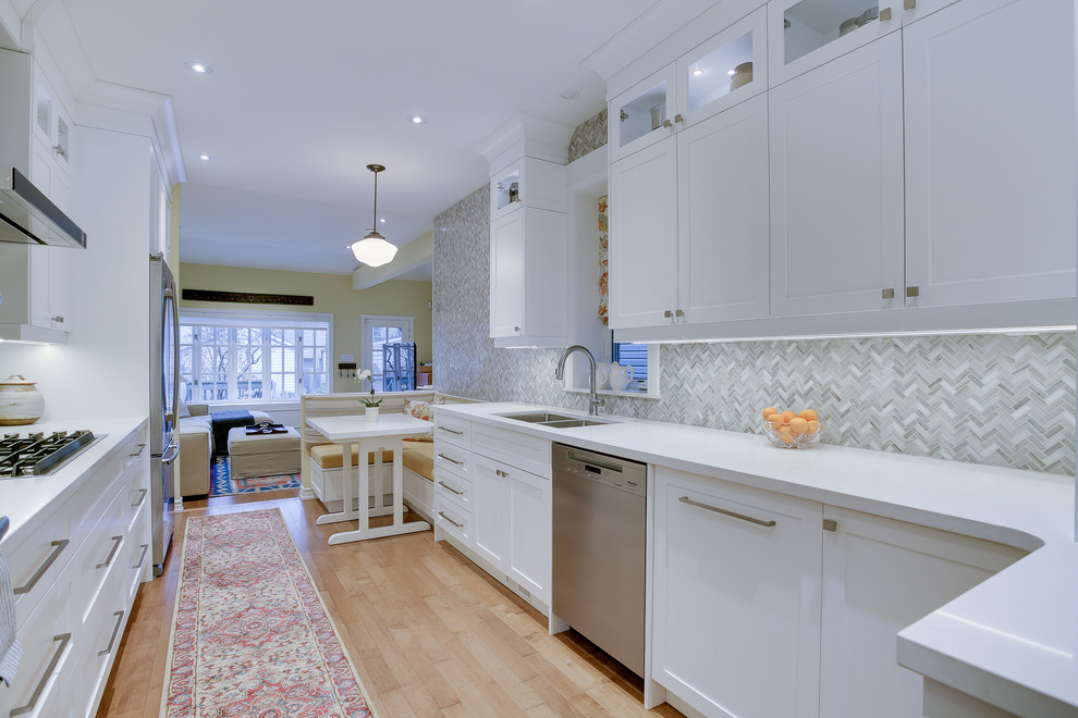 Medium sized traditional galley kitchen in Toronto with a submerged sink, shaker cabinets, white cabinets, grey splashback, stone tiled splashback, stainless steel appliances, medium hardwood flooring, no island and engineered stone countertops.