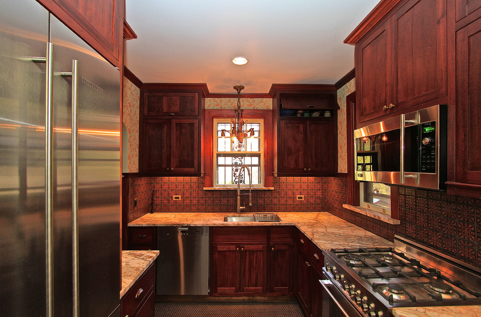 Exempel på ett klassiskt kök, med en undermonterad diskho, luckor med infälld panel, skåp i mörkt trä, marmorbänkskiva, brunt stänkskydd, stänkskydd i keramik och rostfria vitvaror