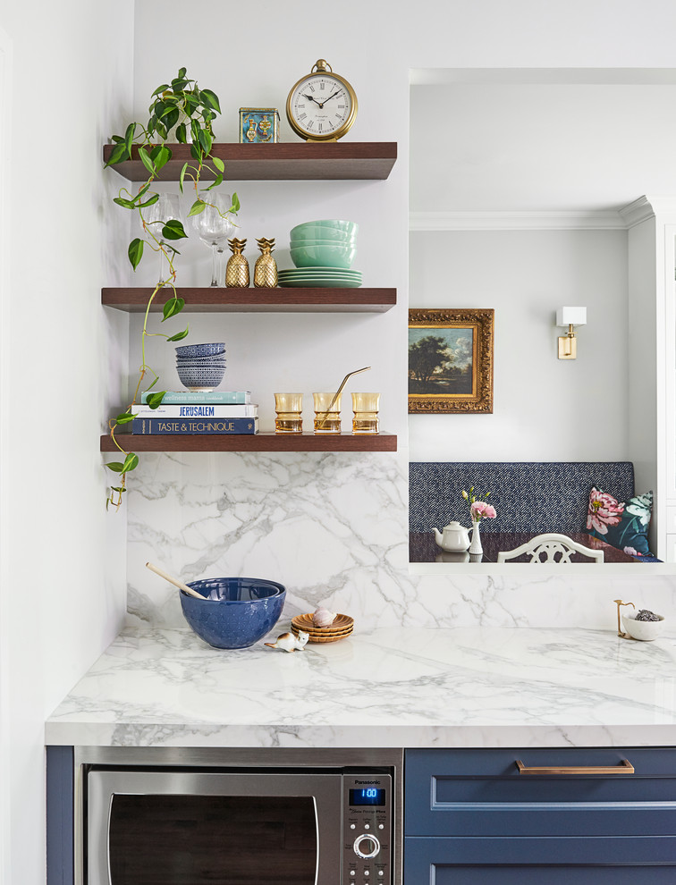 Foto på ett litet vintage vit kök, med en nedsänkt diskho, skåp i shakerstil, blå skåp, marmorbänkskiva, vitt stänkskydd, stänkskydd i marmor, rostfria vitvaror och en köksö