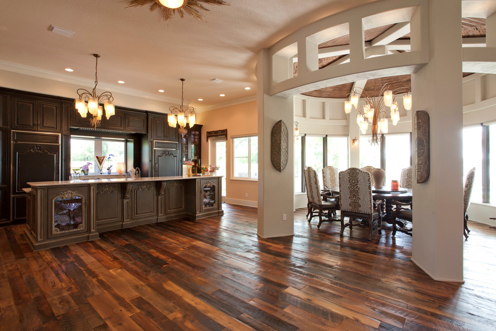 Exempel på ett amerikanskt linjärt kök med öppen planlösning, med luckor med upphöjd panel, skåp i mörkt trä, granitbänkskiva, färgglada vitvaror, mörkt trägolv och en köksö