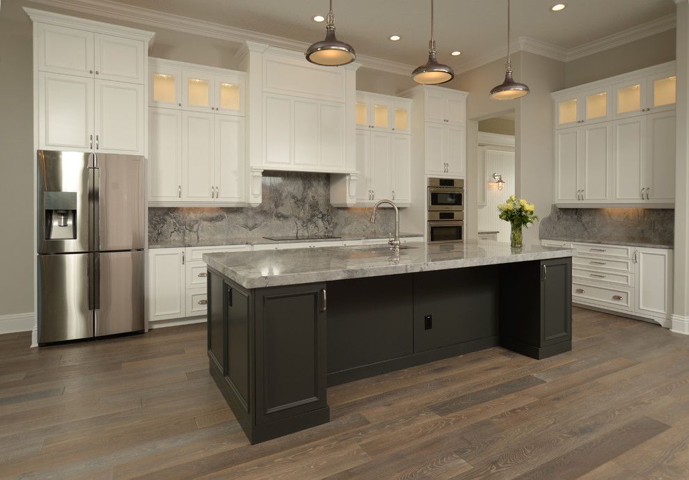 Example of a large island style l-shaped dark wood floor and brown floor eat-in kitchen design in Orlando with beaded inset cabinets, white cabinets, marble countertops, gray backsplash, stone slab backsplash, stainless steel appliances and an island