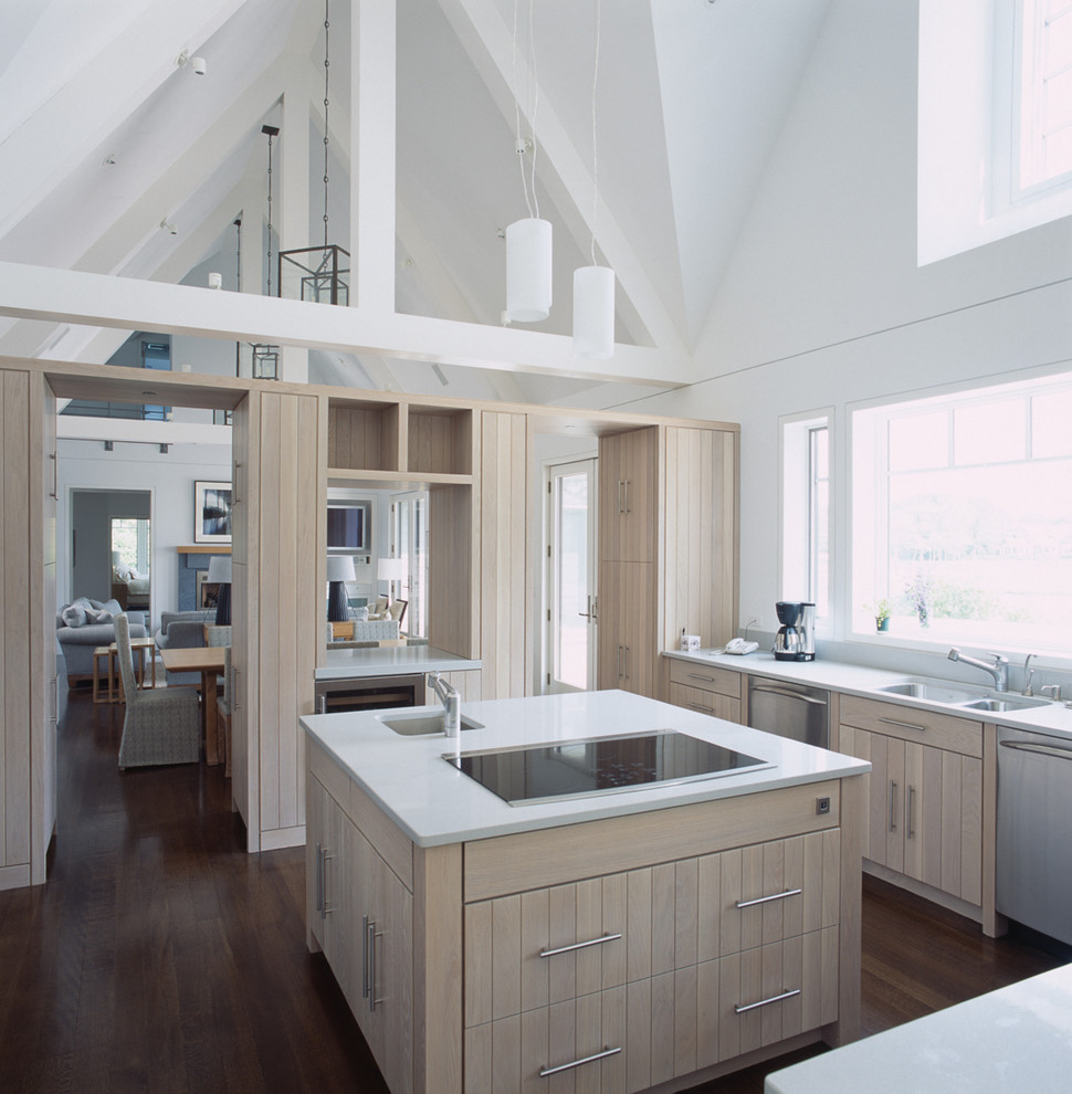 Example of a mid-sized beach style u-shaped dark wood floor eat-in kitchen design in New York with a double-bowl sink, light wood cabinets, stainless steel appliances, quartz countertops and white backsplash