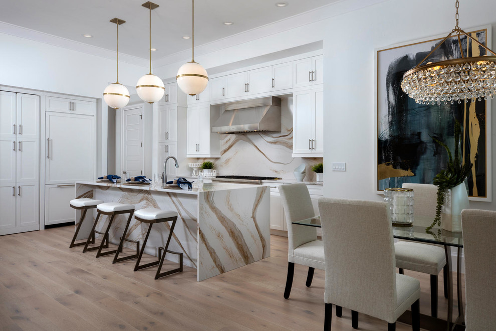 Eat-in kitchen - large contemporary l-shaped light wood floor and beige floor eat-in kitchen idea in Other with shaker cabinets, white cabinets, quartz countertops, metallic backsplash, paneled appliances, an island, white countertops and stone slab backsplash