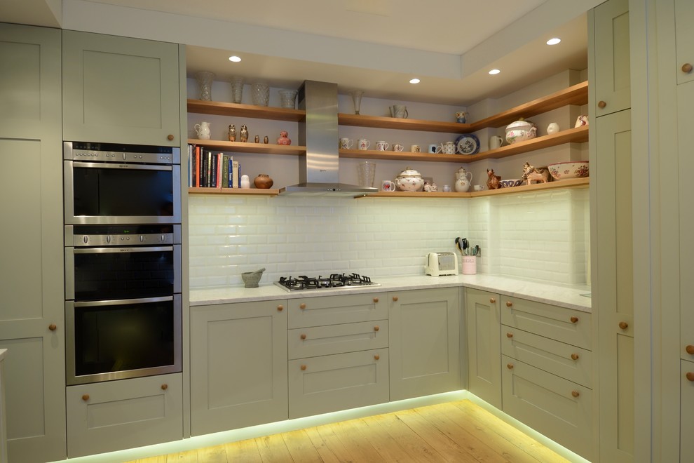 Inspiration for a small scandinavian u-shaped light wood floor enclosed kitchen remodel in London with an integrated sink, shaker cabinets, green cabinets, marble countertops, white backsplash, subway tile backsplash, stainless steel appliances and no island