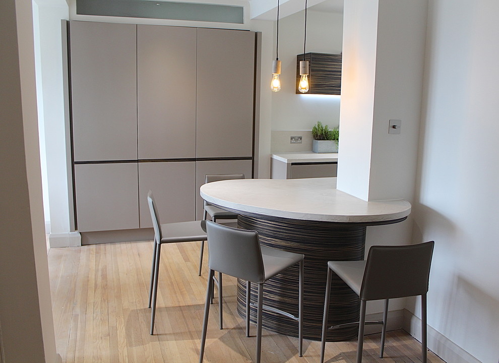Small contemporary galley open plan kitchen in London with a built-in sink, flat-panel cabinets, grey cabinets, concrete worktops, grey splashback, stainless steel appliances, concrete flooring and no island.