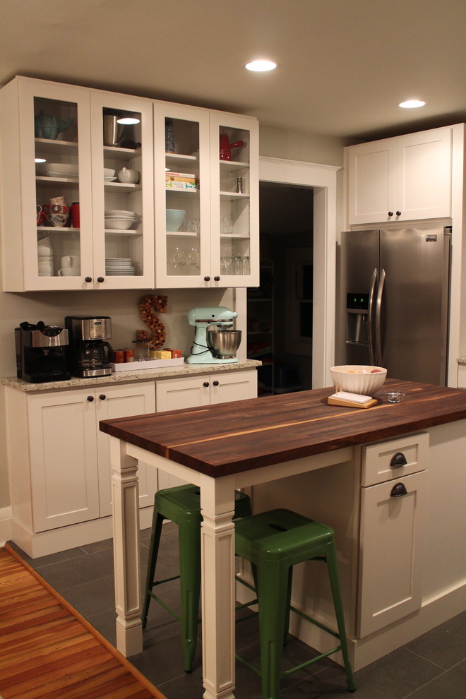 Inspiration för ett mellanstort lantligt kök, med en rustik diskho, luckor med infälld panel, vita skåp, träbänkskiva, grått stänkskydd, rostfria vitvaror, klinkergolv i porslin och en köksö