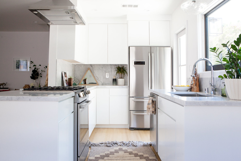 Foto på ett litet 60 tals kök, med en undermonterad diskho, släta luckor, vita skåp, marmorbänkskiva, grått stänkskydd, stänkskydd i sten, rostfria vitvaror, betonggolv och grått golv