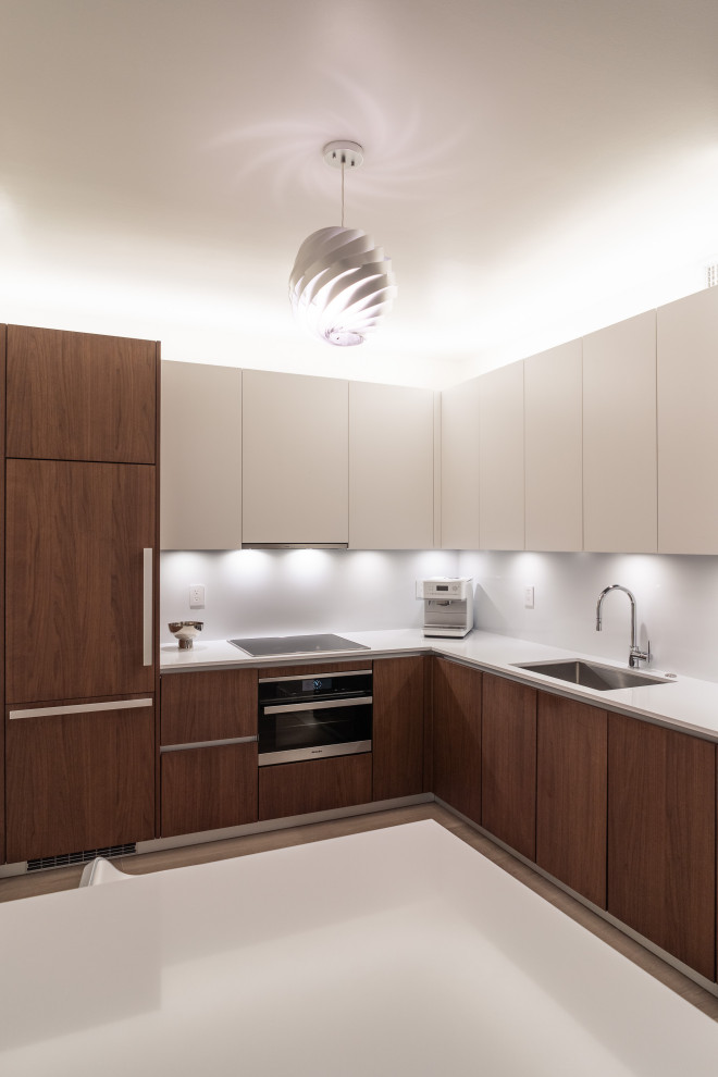 Idéer för ett litet modernt vit kök, med en undermonterad diskho, släta luckor, skåp i mellenmörkt trä, bänkskiva i kvarts, vitt stänkskydd, integrerade vitvaror, ljust trägolv och brunt golv