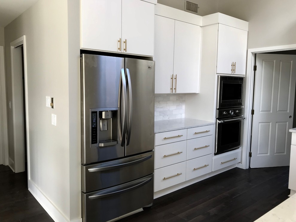 Idéer för att renovera ett mellanstort funkis grå grått kök, med en rustik diskho, släta luckor, vita skåp, bänkskiva i kvarts, grått stänkskydd, stänkskydd i marmor, rostfria vitvaror, mörkt trägolv, en köksö och svart golv