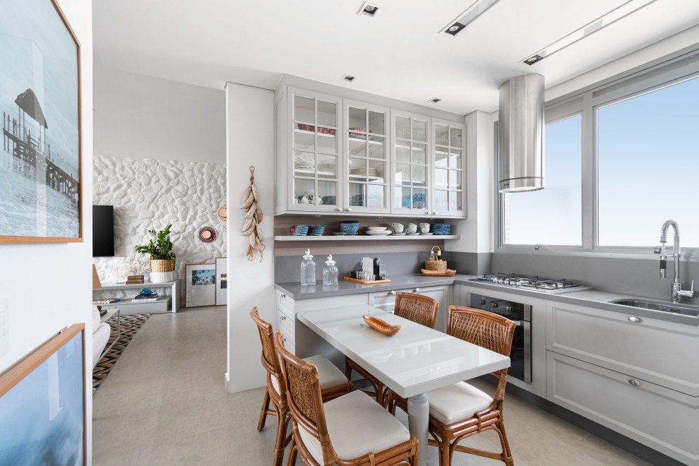 Example of an island style u-shaped gray floor kitchen design in Miami with an undermount sink, recessed-panel cabinets, white cabinets, gray backsplash, stainless steel appliances, a peninsula and gray countertops