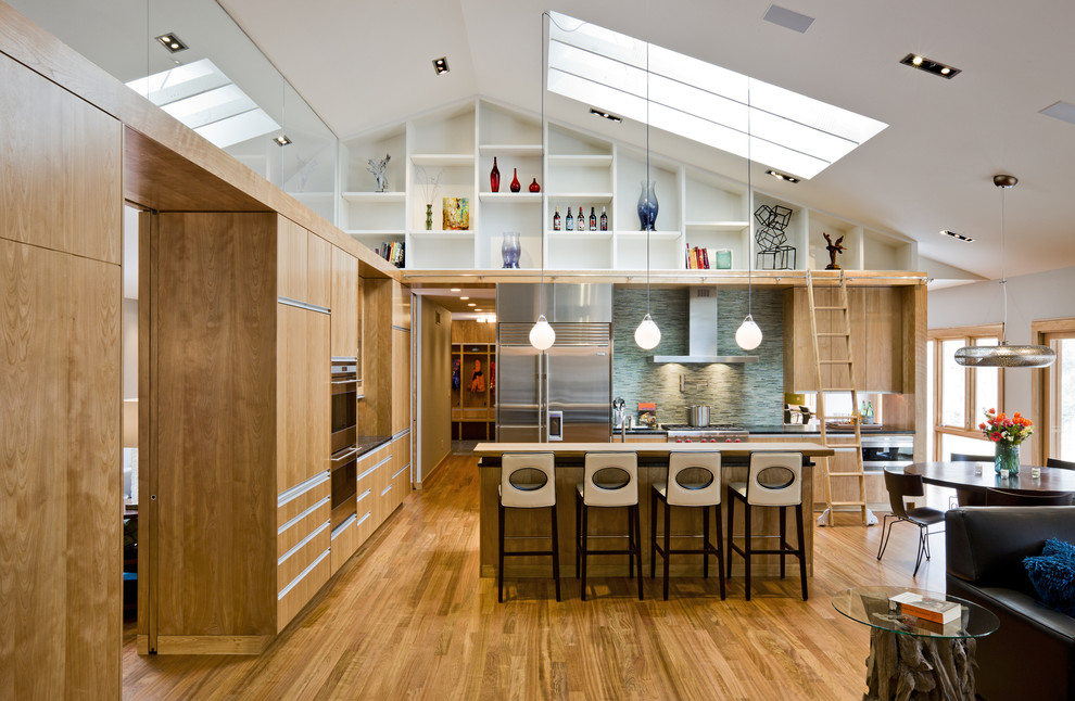 Exemple d'une cuisine ouverte tendance en L et bois brun avec un placard à porte plane, une crédence bleue, une crédence en mosaïque, un électroménager en acier inoxydable, un sol en bois brun et îlot.