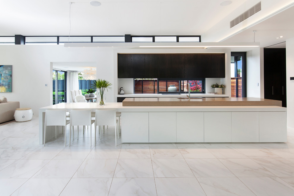 Inspiration för mycket stora moderna vitt kök med öppen planlösning, med en köksö, en dubbel diskho, släta luckor, svarta skåp, fönster som stänkskydd och vitt golv