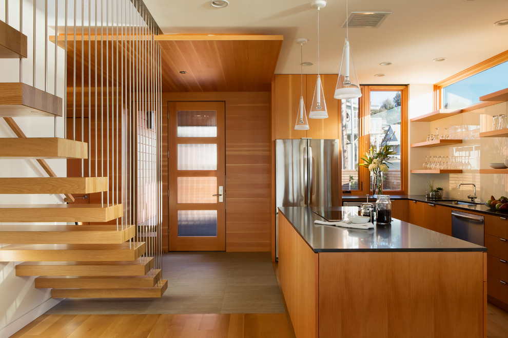 Moderne Küche in L-Form mit Unterbauwaschbecken, offenen Schränken, hellbraunen Holzschränken, Küchenrückwand in Weiß, Glasrückwand, Küchengeräten aus Edelstahl und Kücheninsel in Portland