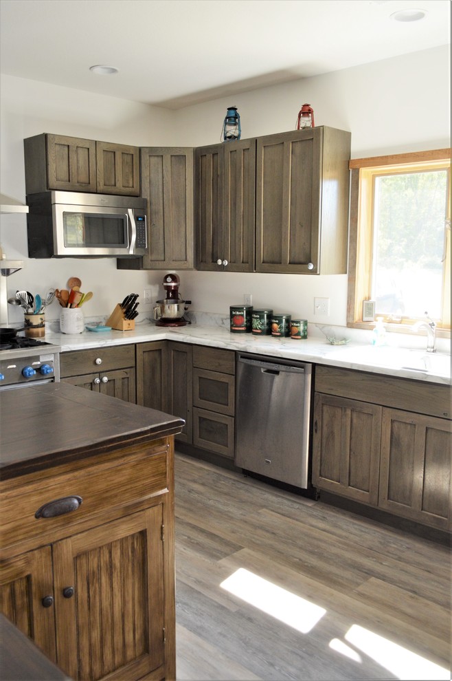 Idéer för stora rustika vitt kök, med en nedsänkt diskho, luckor med infälld panel, grå skåp, laminatbänkskiva, rostfria vitvaror, laminatgolv, en köksö och brunt golv