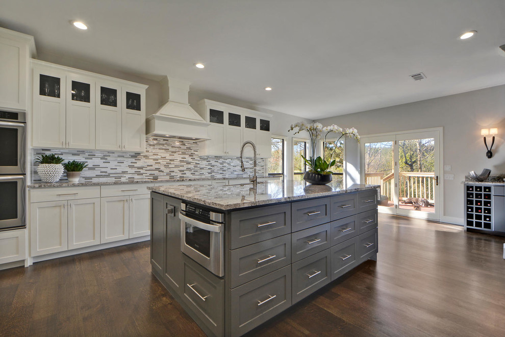 Inspiration for a large transitional l-shaped dark wood floor enclosed kitchen remodel in Austin with an undermount sink, shaker cabinets, white cabinets, granite countertops, gray backsplash, mosaic tile backsplash, stainless steel appliances and an island