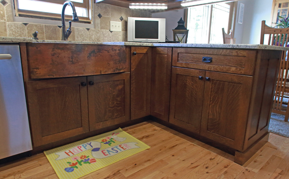 Foto på ett litet lantligt kök, med en rustik diskho, skåp i shakerstil, bruna skåp, granitbänkskiva, beige stänkskydd, stänkskydd i keramik, rostfria vitvaror, ljust trägolv, en halv köksö och gult golv