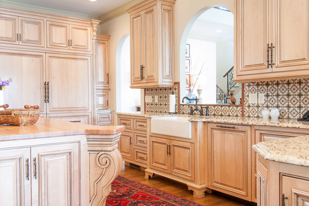 Inspiration for a traditional kitchen in Other with a belfast sink, raised-panel cabinets, light wood cabinets, integrated appliances and an island.