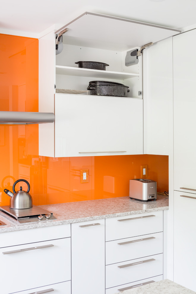 Inspiration för mellanstora moderna kök och matrum, med en dubbel diskho, släta luckor, vita skåp, bänkskiva i kvarts, orange stänkskydd, glaspanel som stänkskydd, rostfria vitvaror och en halv köksö