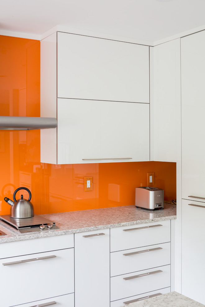 Design ideas for a medium sized modern kitchen/diner in Toronto with a double-bowl sink, flat-panel cabinets, white cabinets, engineered stone countertops, orange splashback, glass sheet splashback, stainless steel appliances and a breakfast bar.