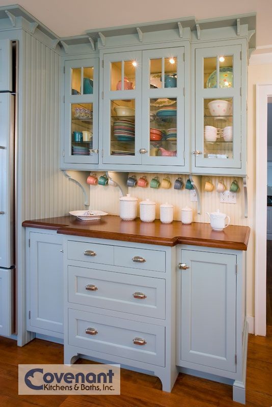 Cette photo montre une cuisine américaine encastrable bord de mer avec des portes de placard bleues, une crédence jaune et un sol en bois brun.