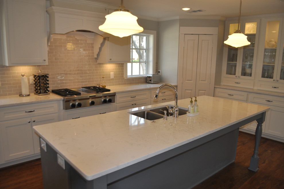 This is an example of a medium sized traditional u-shaped open plan kitchen in Dallas with a submerged sink, shaker cabinets, white cabinets, engineered stone countertops, ceramic splashback, stainless steel appliances, medium hardwood flooring and an island.