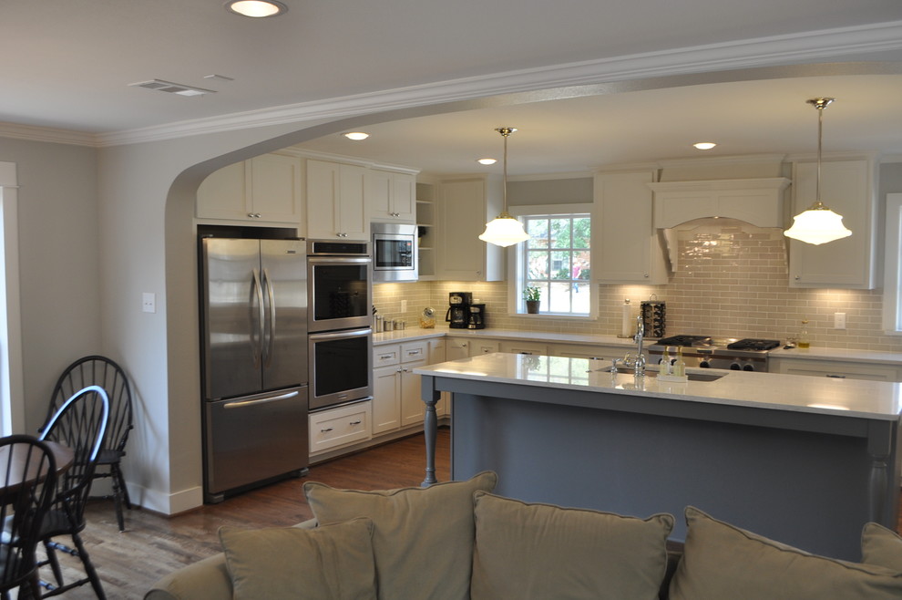 Design ideas for a medium sized traditional u-shaped open plan kitchen in Dallas with a submerged sink, shaker cabinets, white cabinets, engineered stone countertops, ceramic splashback, stainless steel appliances, medium hardwood flooring and an island.