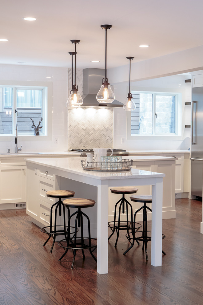 Inspiration for a contemporary l-shaped kitchen/diner in Vancouver with a submerged sink, white cabinets, engineered stone countertops, white splashback and stainless steel appliances.