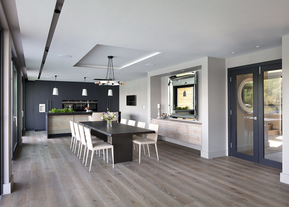 Diseño de cocina lineal actual grande abierta con fregadero bajoencimera, encimera de mármol, suelo de madera clara y una isla