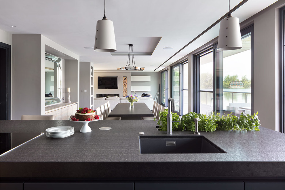 Modern inredning av ett stort linjärt kök med öppen planlösning, med en undermonterad diskho, marmorbänkskiva, ljust trägolv, en köksö och grått golv