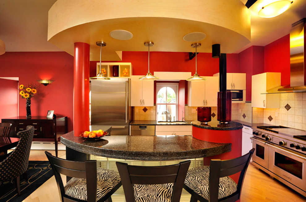 Example of a large trendy l-shaped light wood floor eat-in kitchen design in Other with a drop-in sink, flat-panel cabinets, yellow cabinets, granite countertops, beige backsplash, ceramic backsplash, stainless steel appliances and an island