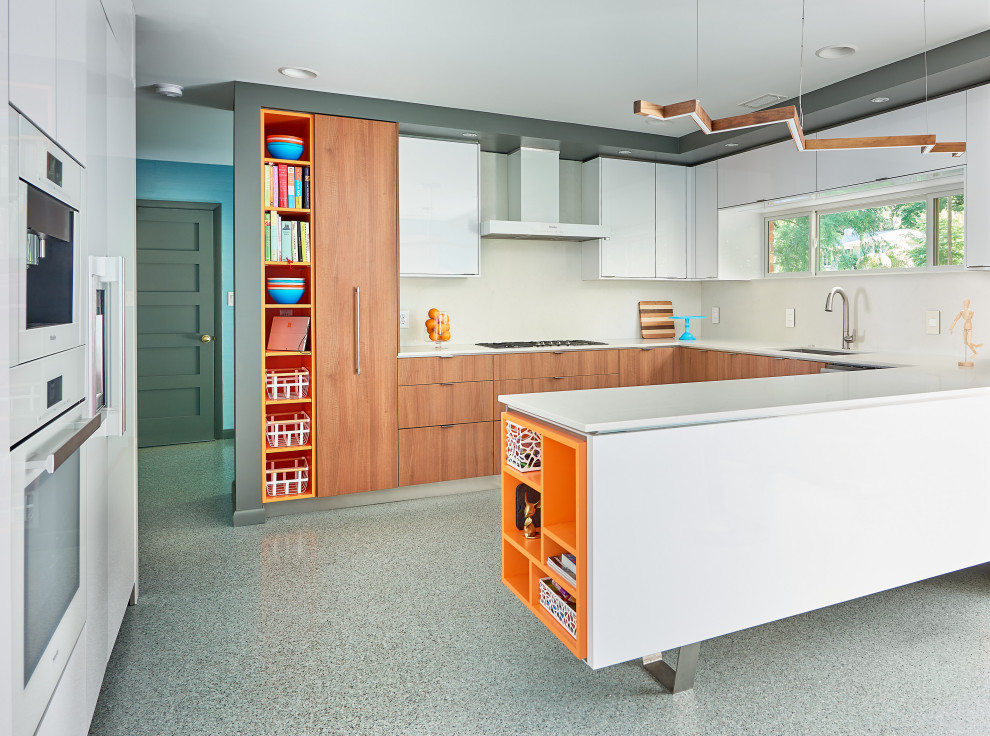 Example of a large 1960s u-shaped terrazzo floor and multicolored floor eat-in kitchen design in Charlotte with an undermount sink, flat-panel cabinets, medium tone wood cabinets, quartz countertops, white backsplash, quartz backsplash, white appliances and white countertops