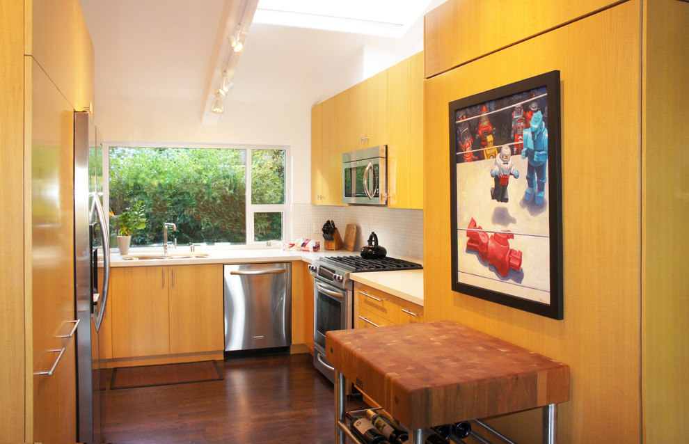 Immagine di una cucina parallela minimalista chiusa e di medie dimensioni con lavello sottopiano, ante lisce, ante in legno chiaro, top in quarzo composito, paraspruzzi giallo, elettrodomestici in acciaio inossidabile e parquet scuro