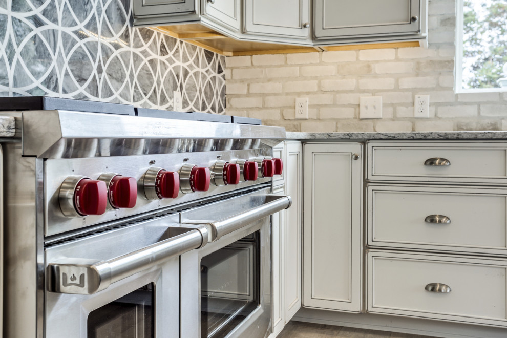 Foto på ett stort vintage flerfärgad kök, med en undermonterad diskho, släta luckor, vita skåp, bänkskiva i kvarts, grått stänkskydd, rostfria vitvaror, ljust trägolv, en köksö, brunt golv och stänkskydd i mosaik
