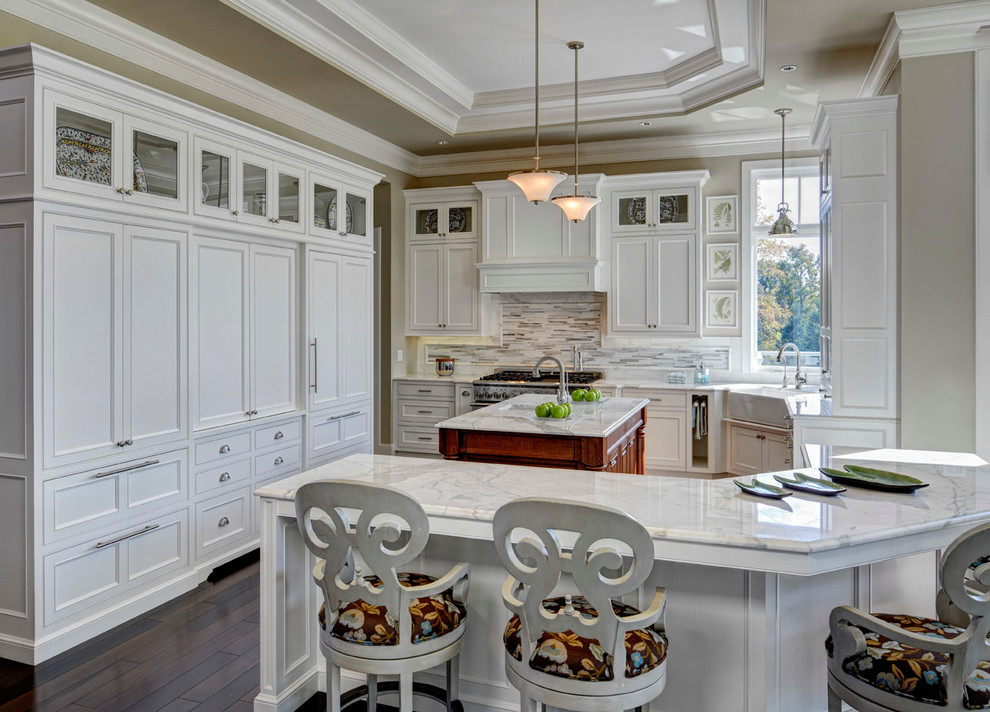 Modelo de cocina comedor tradicional con fregadero sobremueble, armarios con paneles empotrados, puertas de armario blancas, salpicadero multicolor y electrodomésticos con paneles